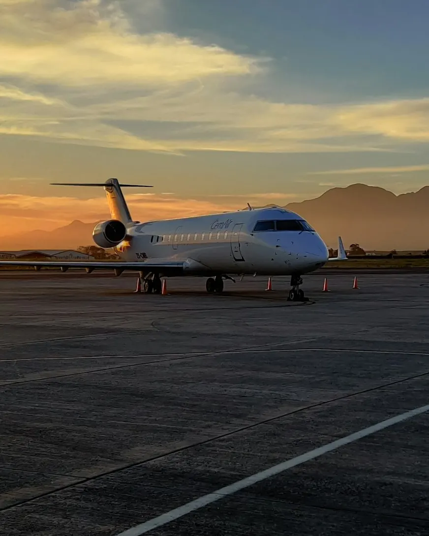 Business jet on a ramp at sunset with mountains in the distance