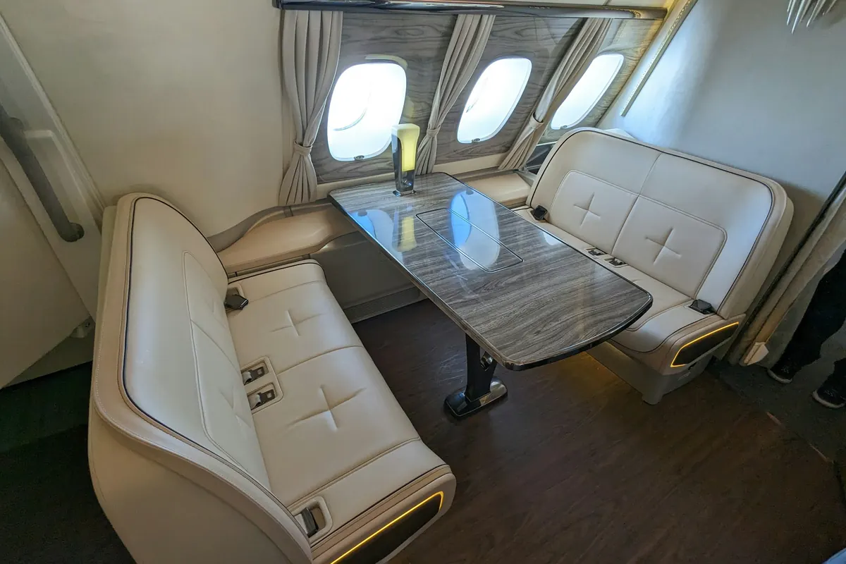 Large-cabin jet interior with club seats around a table